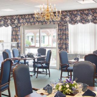 A well-decorated dining room with elegant furniture and floral arrangements.