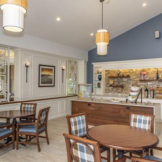 A cozy cafe interior featuring tables and chairs, with a focus on modern decor and lighting.