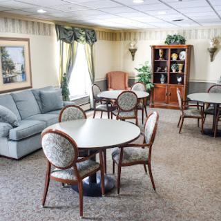 A cozy lounge area featuring round tables, chairs, and a comfortable sofa.