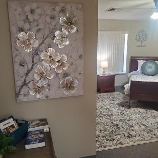 A cozy bedroom with floral artwork and a well-arranged interior.