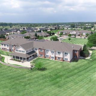 Aerial view of a suburban residential building surrounded by grassy areas.