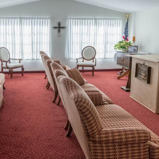 A traditional living room with patterned chairs and a red carpet.