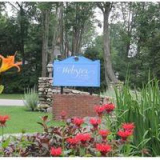 A landscaped entrance with a sign surrounded by vibrant flowers and greenery.