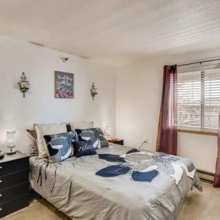 A cozy bedroom with a neatly made bed, nightstands on either side, and a window with curtains.