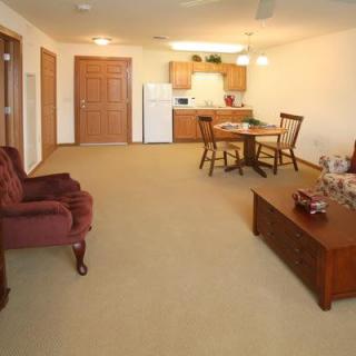 A spacious living room area with a dining table and chairs near the kitchen.