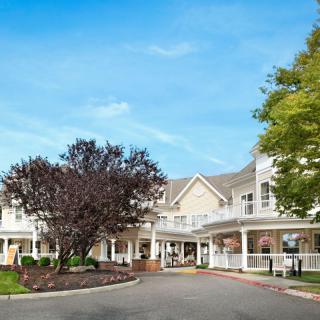 A scenic view of a large building with an inviting entrance surrounded by trees.