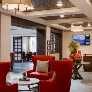 A modern lobby with red seating, stylish lighting, and decorative elements.