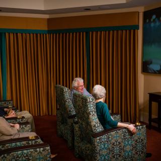 A group of seniors enjoying a movie in a cozy living room setting.