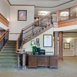 A welcoming hotel lobby featuring a grand staircase and a reception desk.