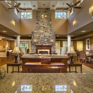 A spacious living room with a large stone fireplace and elegant interior decor.