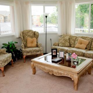 A cozy living room with patterned furniture and a glass coffee table.