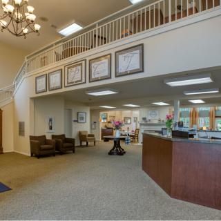 A spacious and well-lit lobby with a reception desk, seating area, and decorative elements.