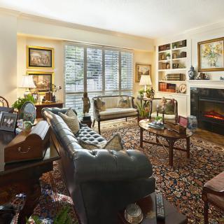 A cozy living room with elegant furniture, a rug, and a fireplace.