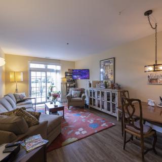 A cozy living room with a sofa, dining area, and various decorative elements.