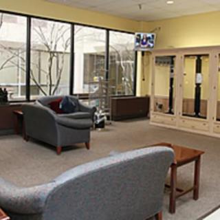 A comfortable lobby area with seating, tables, and large windows.