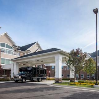 A building with a covered entrance and a vehicle parked on the driveway.