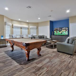 A spacious and inviting recreation room featuring a pool table and comfortable seating.