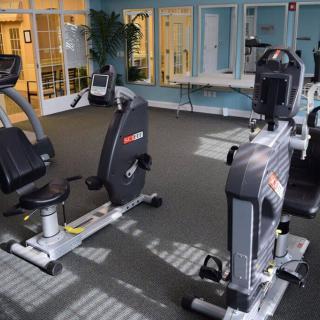 A gym setting featuring stationary bikes and various exercise equipment.