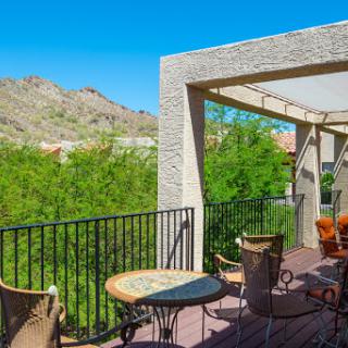 A cozy balcony with comfortable seating and a stunning view of the mountains, perfect for enjoying sunny days.