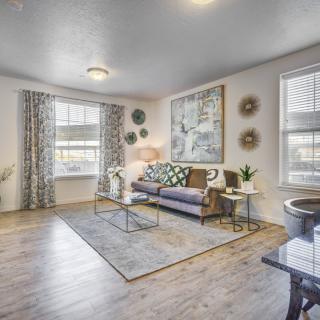 A modern living room with stylish decor and furniture, featuring a comfortable sofa, coffee table, large windows, and contemporary artwork.