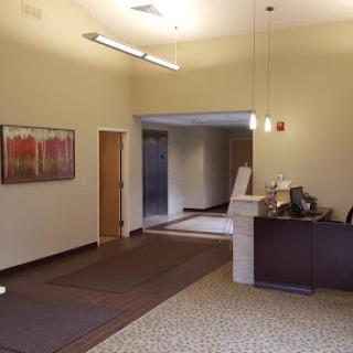A spacious and modern reception area featuring warm lighting and contemporary art.