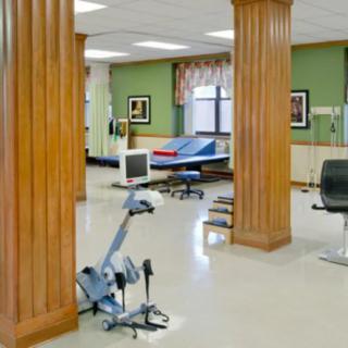 A spacious exercise room with fitness equipment and wooden pillars.