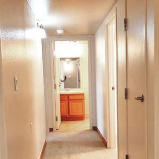 A narrow hallway with several doors leading to different rooms.