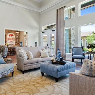 A spacious and well-lit living room with modern furniture and large windows.