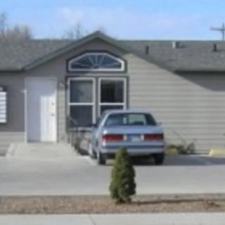 A suburban house with a parked car in the driveway.