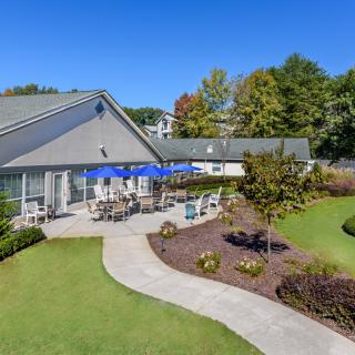 A beautiful outdoor patio area surrounded by a well-maintained garden.
