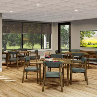 A modern dining area with wooden tables and chairs, surrounded by large windows.