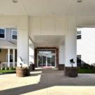 Entrance of a modern building with white columns and a covered walkway.