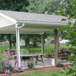 A cozy outdoor patio surrounded by greenery and flowers, perfect for relaxation.