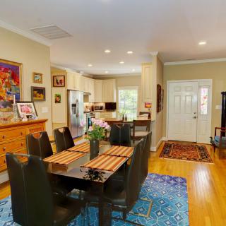 An open floor plan featuring a modern kitchen and dining area with hardwood floors and decorative rugs.