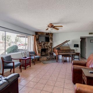 A cozy living room featuring a grand piano, comfortable seating, and a warm ambiance.
