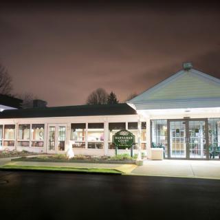 A well-lit building at night with a cloudy sky.