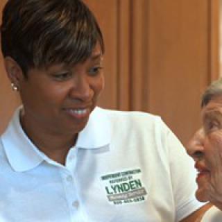A caregiver interacts with a senior, providing assistance and support.