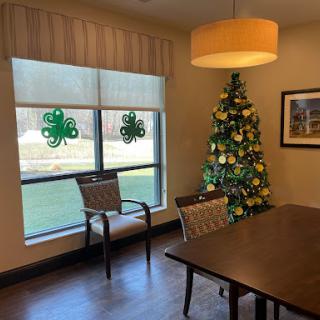A cozy dining area featuring a decorated Christmas tree and festive window adornments.