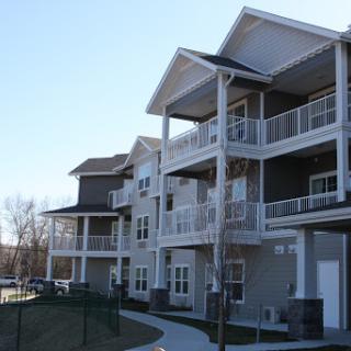 A modern apartment complex featuring multiple levels and balconies.