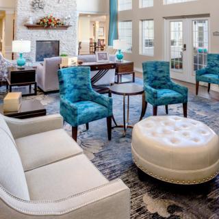 A modern living room with blue chairs and a white sofa, featuring stylish interior design.