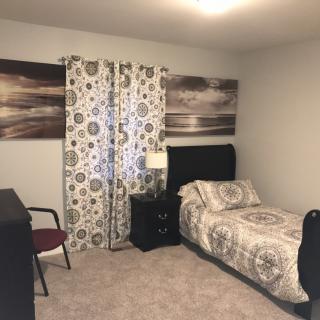 A cozy bedroom with a single bed and patterned decor.