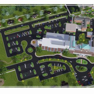 An aerial view of a building complex with surrounding parking lots and landscaped areas.
