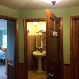A view of a hallway with doors leading to a bathroom and another room.