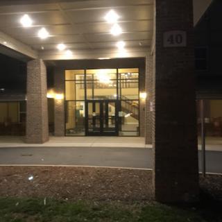 A well-lit entrance of a modern building captured at night.