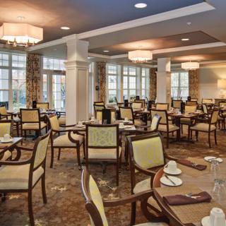 A spacious and elegantly decorated dining room with neatly arranged tables and chairs.