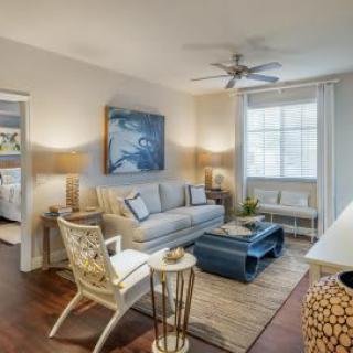 A modern living room with elegant decor, featuring a comfortable sofa, stylish coffee table, and large window illuminating the space.