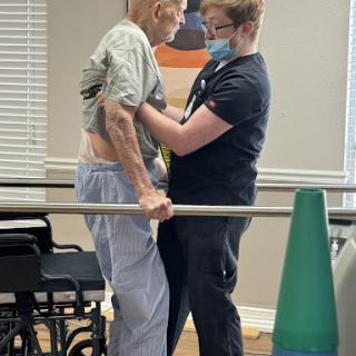 A healthcare professional assists a patient during a rehabilitation session.