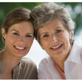 Two women smiling outdoors together.