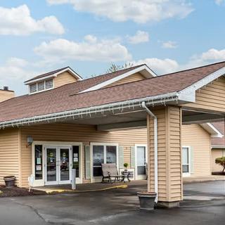 A front view of a hotel entrance with a covered driveway on a clear day.