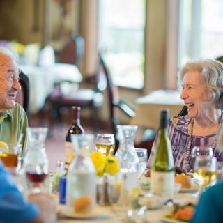 Elderly group happily dining together at a restaurant.
